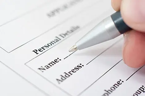 A new-patient form being completed with a pen.